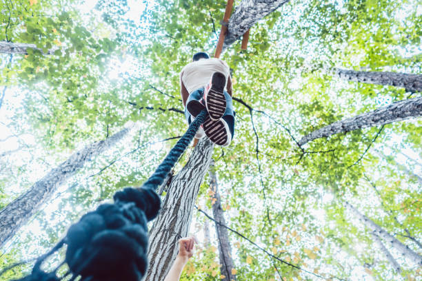 istock Very fit and athletic man climbing a rope 985785916