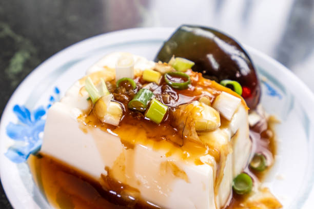 istock Taiwan's distinctive famous snacks: thousand-year-old eggs tofu(pidan tofu) in a white plate on stone table, Taiwan Delicacies, Taiwan Street Food 985796808