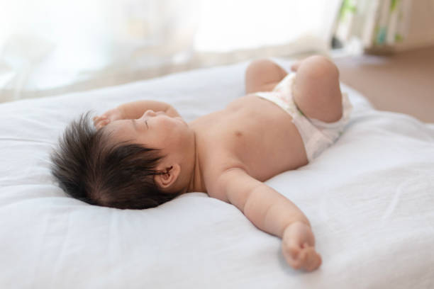 istock Newborn baby sleeping in bright living room 985802094