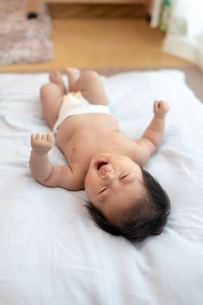 новорожденный ребенок зевая в яркой гостиной - baby yawning asian ethnicity newborn стоковые фото и изображения