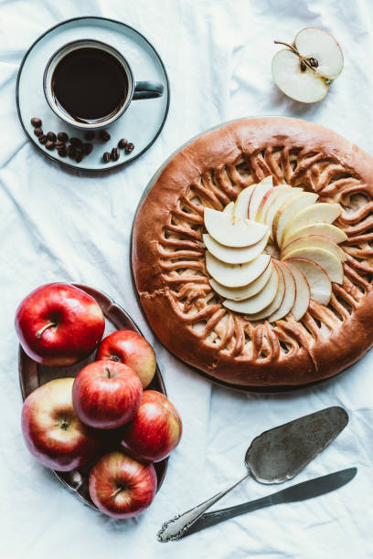istock flat lay with cup of coffee, apple pie and fresh apples on white tablecloth 985807394