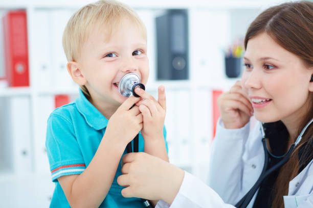 istock Little boy plays with stethoscope during visit to a doctor. 985808030