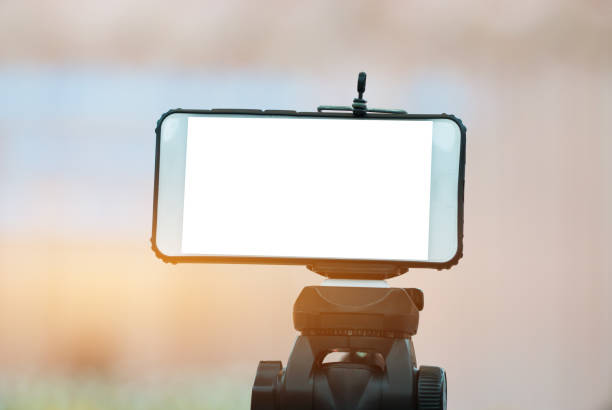istock LCD Screen Blank smartphone on Tripod for copy space in your text message or promotional content, advertising mock up empty insert for coutomer Background. 985811132
