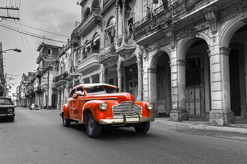 Vintage classic red american oldtimer car in old town of Havana Cuba on black and white background