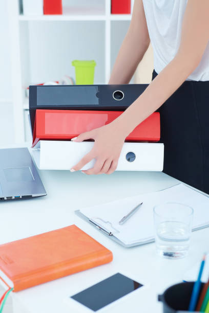 istock Closeup woman's hands holding stack of folders. 985816522