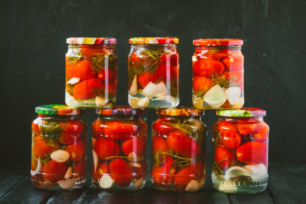 istock Several jars of canned tomatoes with ripe tomatoes and garlic 985817098