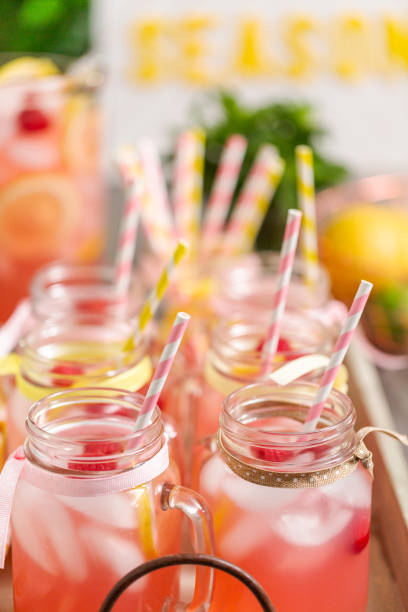 istock Raspberry lemonade garnished with fresh lemon and raspberries in drinking mason jars. 985820952