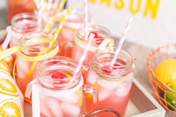 istock Raspberry lemonade garnished with fresh lemon and raspberries in drinking mason jars. 985821012