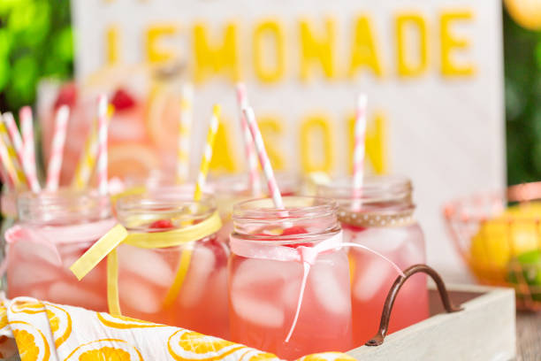 istock Raspberry lemonade garnished with fresh lemon and raspberries in drinking mason jars. 985821020