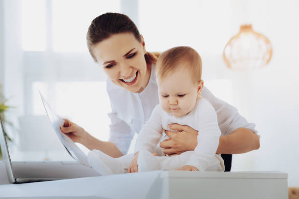 istock Positive delighted worker spending time with baby 985821126