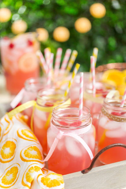 istock Raspberry lemonade garnished with fresh lemon and raspberries in drinking mason jars. 985821194