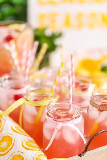 istock Raspberry lemonade garnished with fresh lemon and raspberries in drinking mason jars. 985821218