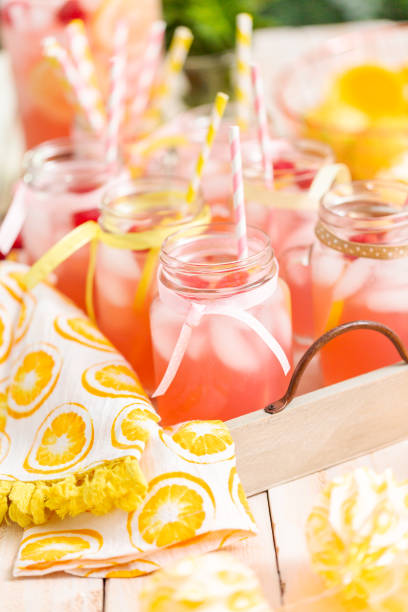 istock Raspberry lemonade garnished with fresh lemon and raspberries in drinking mason jars. 985821232