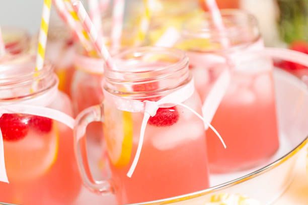 istock Raspberry lemonade garnished with fresh lemon and raspberries in drinking mason jars. 985821270