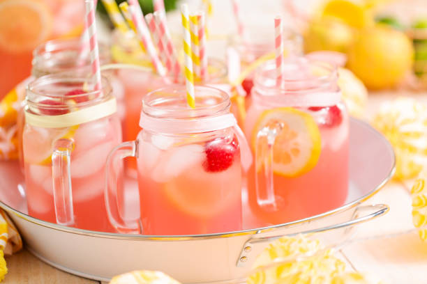istock Raspberry lemonade garnished with fresh lemon and raspberries in drinking mason jars. 985821294