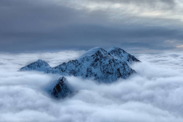 Photo of Snowy peak above the clouds