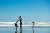 父と娘とビーチで遊ぶにドーベルマン