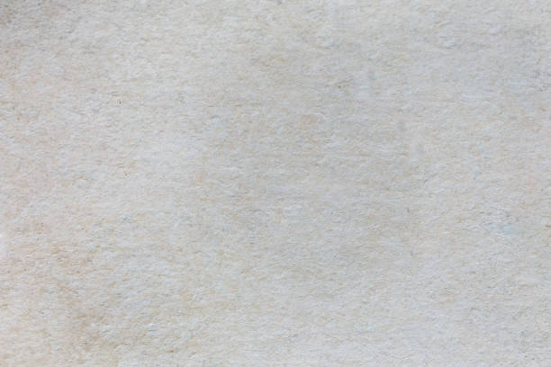 istock Abstract white beige texture. Ribbed concrete background with small holes and stains. Old vintage wall. 985832628