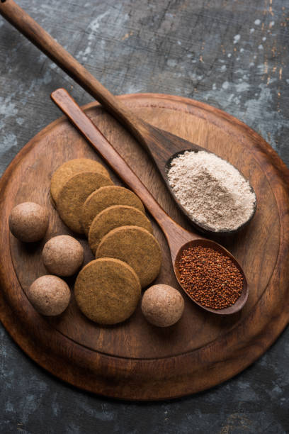 istock Nachni / Ragi laddu and biscuits or cookies made using  finger millet, sugar and ghee. It's a healthy food from India. Served in a bowl or plate with raw whole and powder. Selective focus 985833320
