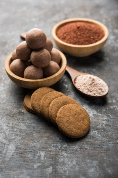 istock Nachni / Ragi laddu and biscuits or cookies made using  finger millet, sugar and ghee. It's a healthy food from India. Served in a bowl or plate with raw whole and powder. Selective focus 985835986