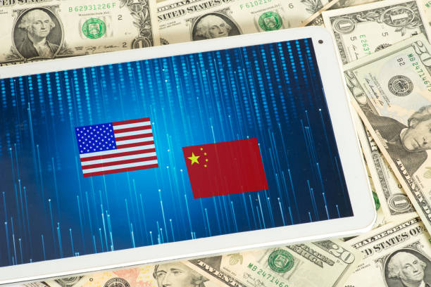 istock Dollar banknotes, Tablet PC and flags of USA and China 985843532