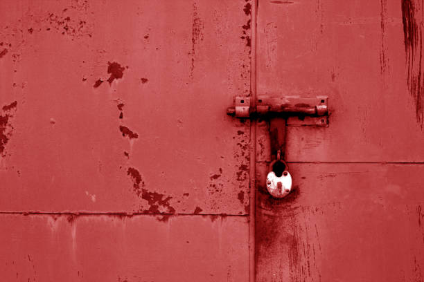 istock Old padlock on metal gate in red color. 985847240