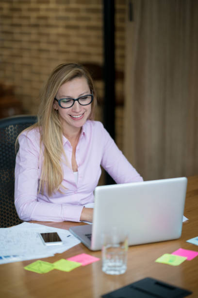 istock Happy woman working on a laptop computer at a co-working space 985848820