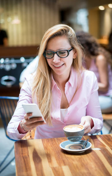 istock Woman texting on her cell phone having a cup of coffee 985849300