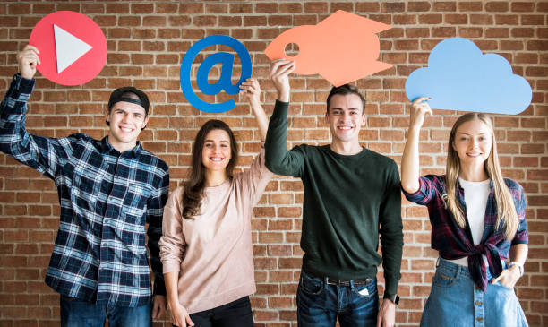 istock Friends holding up social media and technology concept icons 985849310
