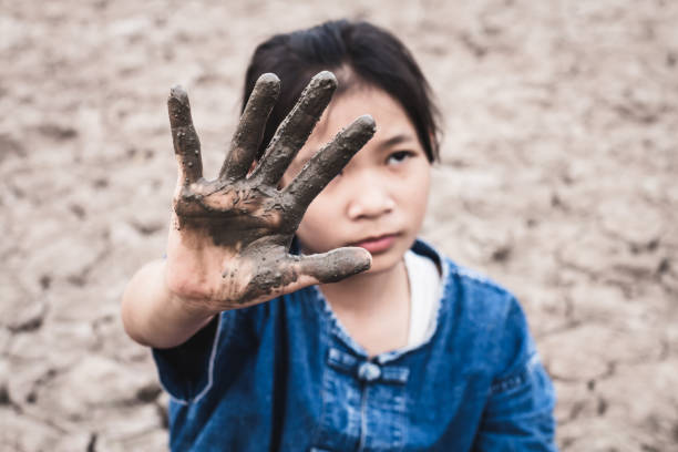 istock Girl With Muddy Hand On Drought Field 985852078
