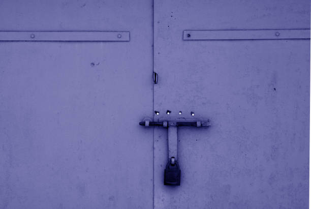 istock Old padlock on metal gate in blue color. 985853004