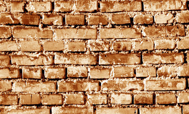istock Grungy weahered brick wall in orange tone. 985854258