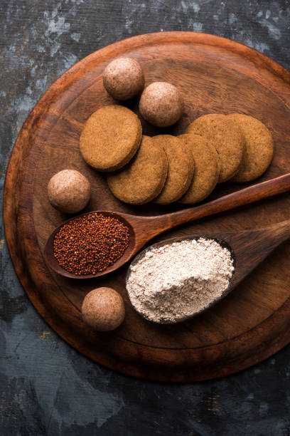 istock Nachni / Ragi laddu and biscuits or cookies made using  finger millet, sugar and ghee. It's a healthy food from India. Served in a bowl or plate with raw whole and powder. Selective focus 985864236