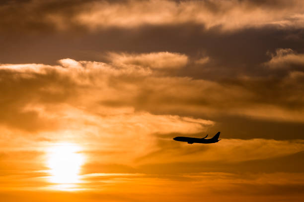 istock A plane flying towards a beautiful sunset 985864330