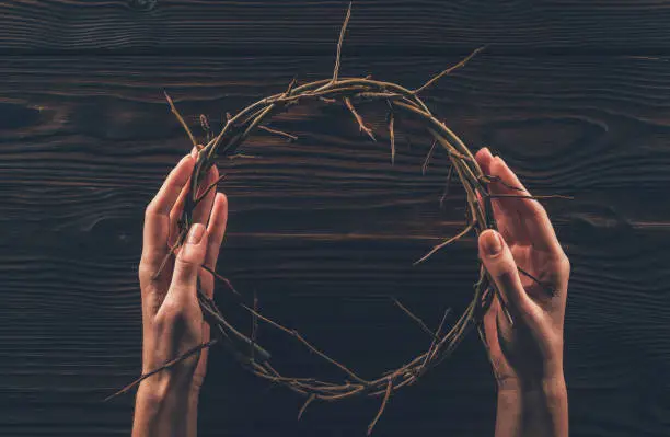 cropped image of woman holding crown of thorns in hands