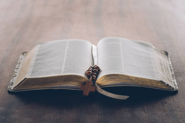 istock open holy bible and rosary with cross on wooden table 985870026