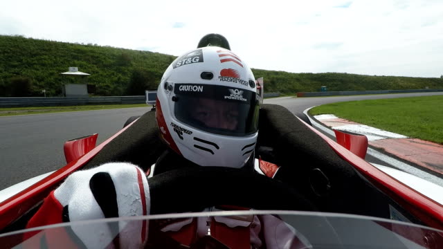 Racing driver in cockpit steering open-wheel single-seater racing car car