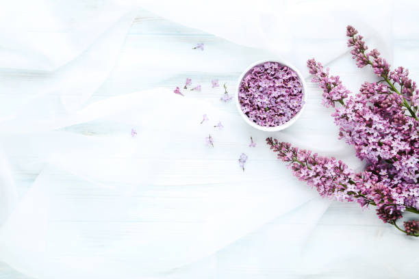istock Lilac flowers in bowl on white cloth 985878056