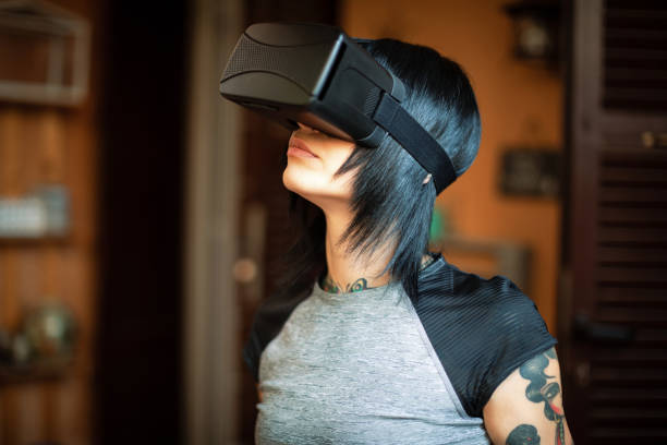 istock Young woman looks fascinated into Virtual Reality Headset 985879370