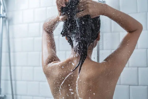 Photo of Asian women bathing and she was bathing and washing hair.she is happy