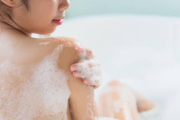 le donne usano il sapone. detersori il corpo che è nella vasca da bagno - corpo di animale foto e immagini stock