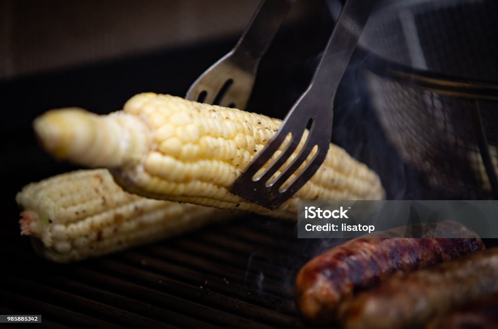 Taking Corn off the Grill Barbecue - Meal Stock Photo