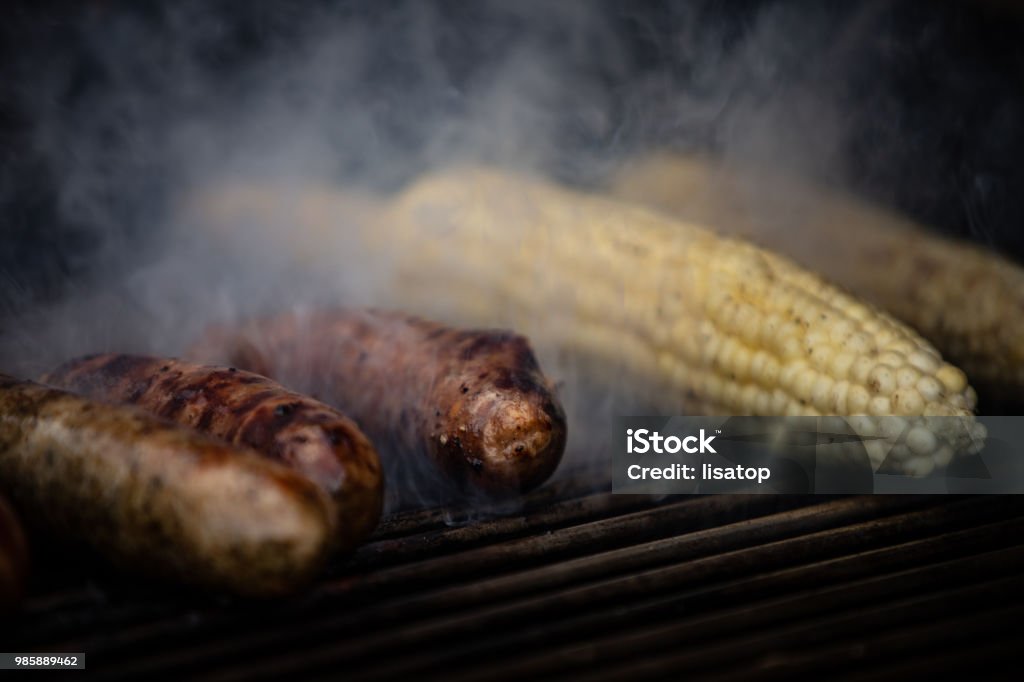 Grilling Sausage and Corn Taking Corn off the Grill Barbecue - Meal Stock Photo