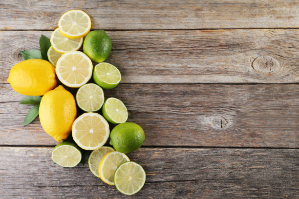 istock Ripe limes and lemons on wooden table 985894028