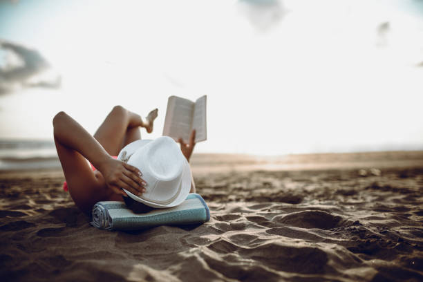 istock Attractive Female Enjoying Summer Vacation And Reading Book On Beach 985894212
