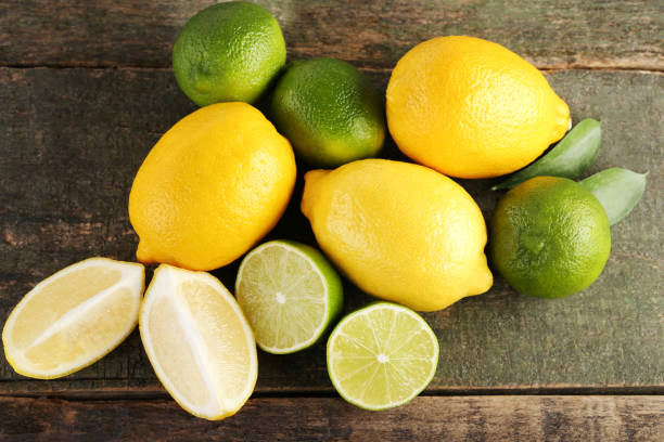 istock Ripe limes and lemons on wooden table 985894262