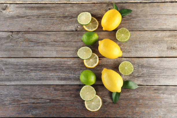 istock Ripe limes and lemons on wooden table 985895530
