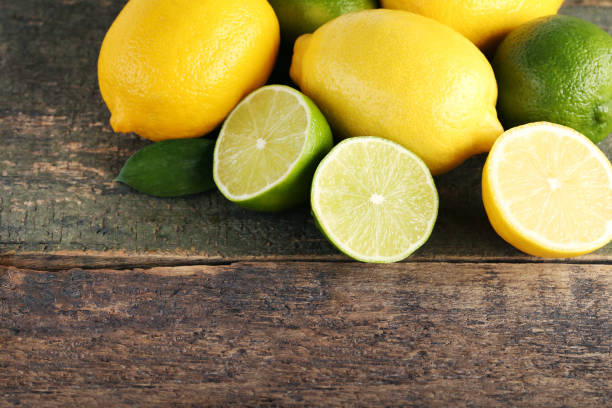 istock Ripe limes and lemons on wooden table 985898732