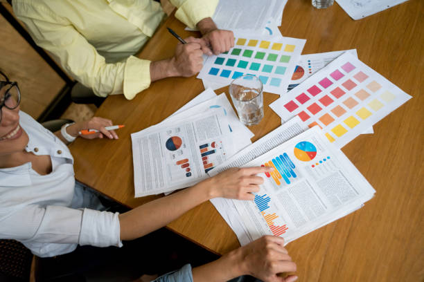 istock Business people in a meeting at the office looking at documents 985899468