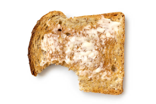 istock Buttered slice of whole wheat toast isolated on white from above. Bite missing. 985900022